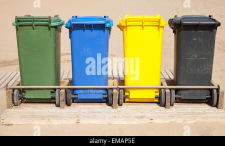 Colorati contenitori di plastica in una fila per separare le operazioni di garbage collection, vista frontale Foto Stock