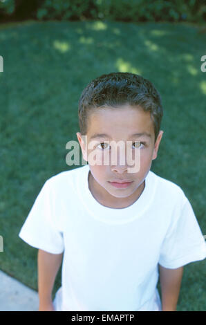 Ritratto di apprensione giovane ragazzo in cortile Foto Stock