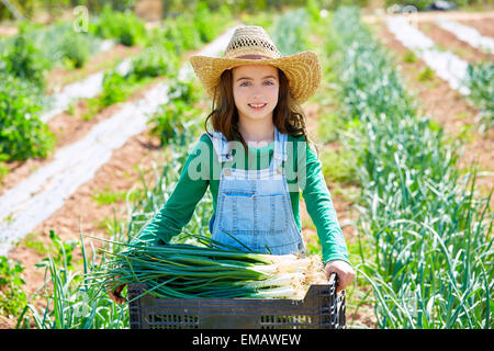 Un piccolo agricoltore di capretto ragazza in onion harvest in Orchard Foto Stock