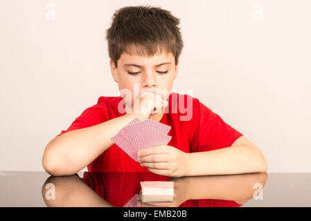 Considerato giovane ragazzo giocando a carte Foto Stock