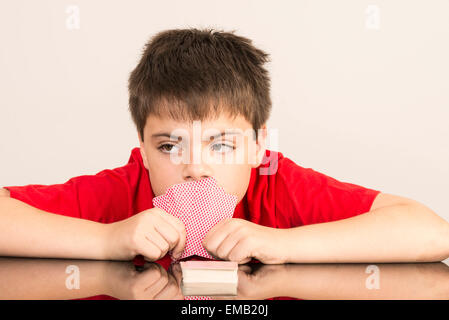 Considerato giovane ragazzo giocando a carte Foto Stock