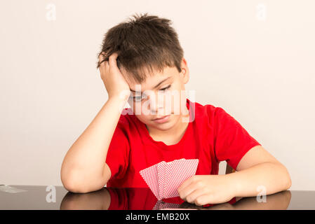 Considerato giovane ragazzo giocando a carte Foto Stock