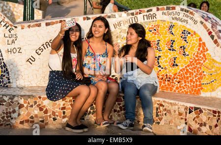 Il Perù, Lima, Miraflores. Tre giovani donne che prendono un Selfie all amore Park (Parque del Amor). Foto Stock