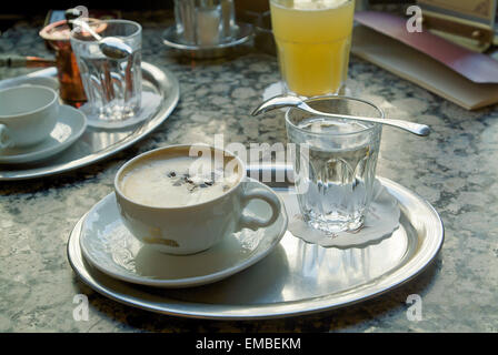 Cappuccino e un bicchiere di acqua sul tavolo in Cafe Central, in background più bevande Vienna Austria Europa Foto Stock