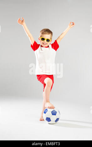 Carino piccolo uomo a giocare il gioco del calcio Foto Stock