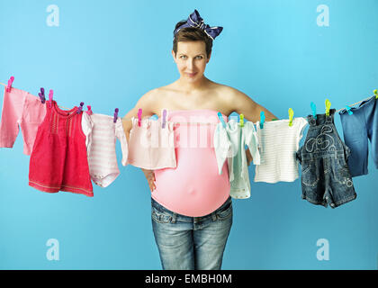 Bella donna incinta facendo il servizio lavanderia Foto Stock