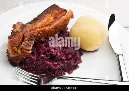 Pancetta di maiale arrosto con cumino condito scoppiettante, crauti rossi e stile tedesco gnocco di patate Foto Stock