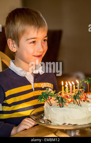 Sette anni di vecchio ragazzo che un desiderio prima di soffiare le candeline sulla sua torta di compleanno in Issaquah, Washington, Stati Uniti d'America Foto Stock