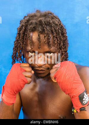 Close-up verticale di un pugile afro-cubane tenendo la sua rosso avvolto a suon di pugni fino durante una sessione presso il Rafael Trejo Boxing palestra. Foto Stock