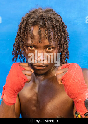 Close-up verticale di un pugile afro-cubane tenendo la sua rosso avvolto a suon di pugni fino durante una sessione presso il Rafael Trejo Boxing palestra. Foto Stock