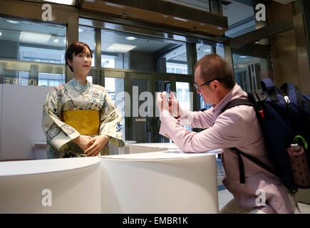 Tokyo, Giappone. Xx Apr, 2015. Un uomo prende una foto del Giappone della high-tech gigante della Toshiba robot umanoide 'Aiko Chihira' in testa store di Nihonbashi Mitsukoshi dipartimento in Tokyo, Giappone, 20 aprile 2015. Android è in carica della ricezione presso il department store da aprile 20-21. © Stringer/Xinhua/Alamy Live News Foto Stock