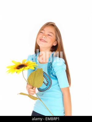 Una giovane ragazza piuttosto tenendo un girasole e sorridente, isolate su sfondo bianco. Foto Stock