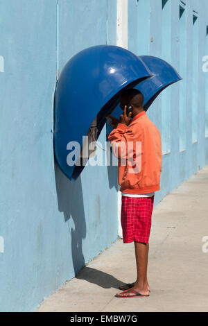 Uomo in piedi in phonebooth a Cienfuegos, Cuba. Foto Stock