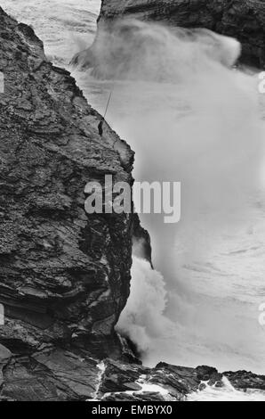 Grave seascape drammatica con il pescatore in Capo San Vicent scogliere sulla costa atlantica Foto Stock