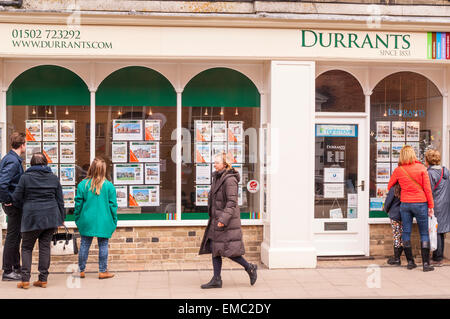 Le persone che cercano in Durrants agente immobiliare nella finestra Southwold , Suffolk , Inghilterra , Inghilterra , Regno Unito Foto Stock