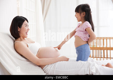 La bambina ha sottolineato la madre di ventre Foto Stock