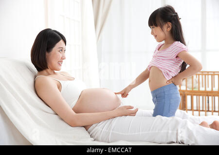 La bambina ha sottolineato la madre di ventre Foto Stock