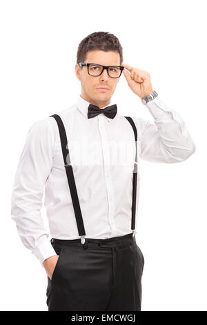 Colpo verticale di un elegante guy tenendo i suoi occhiali e guardando la telecamera isolata su sfondo bianco Foto Stock