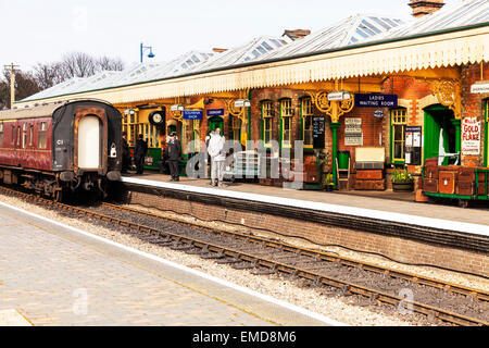 Sheringham vicina piattaforma bagagli treno passeggeri in attesa di guida del binario della linea ferroviaria North Norfolk REGNO UNITO Inghilterra Foto Stock