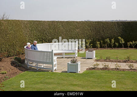 Un paio di sedersi e godersi il sole a Emmetts Giardini in Kent Foto Stock