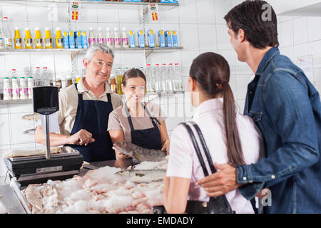 Paio di acquisto nel mercato del pesce di un salmone bianco Foto Stock