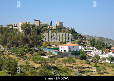 Vista del bianco lavato villaggio di Monda con Al-Mundat Castello, Sierra de las Nieves, Spagna meridionale, l'Andalusia. Foto Stock