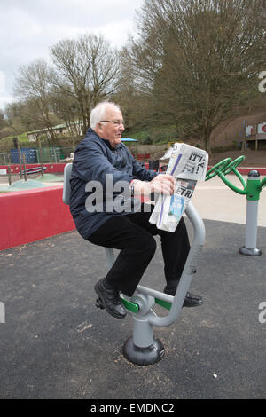 Coppia di anziani nel loro tardi anni settanta (lei) e primi anni ottanta (lui) esercitando su outdoor attrezzature fitness, Kingsbridge, Devon, Regno Unito Foto Stock