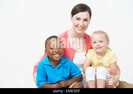 Ritratto in studio di Pre femmina insegnante della scuola con gli alunni Foto Stock