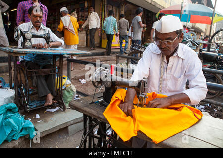 Sarti utilizzando macchine da cucire nel quartiere del mercato della città vecchia di Bijapur Foto Stock