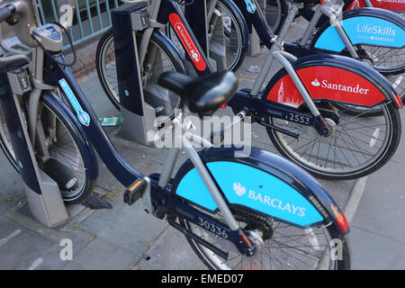 Le biciclette con Barclays e branding di Santander seduti fianco a fianco, come parte di Londra noleggio bici a regime. Focus sul logo di Santander. Foto Stock