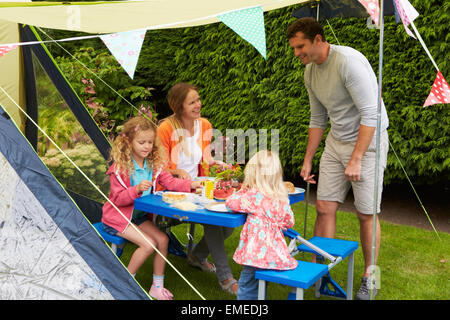 Famiglia godendo di pasto fuori tenda sulla vacanza in campeggio Foto Stock