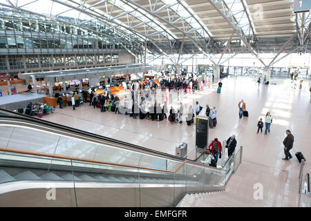 I turisti con le valigie presso l'aeroporto di Amburgo con area check in Foto Stock