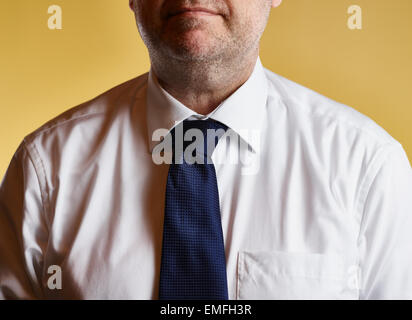 Close up, maschio che indossa una camicia bianca e cravatta blu, sfondo giallo Foto Stock