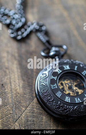Chiusura del vecchio orologio da tasca sul rustico sfondo di legno