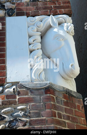 Scolpita in pietra testa di cavalli su un angolo della casa di mattoni parete Foto Stock