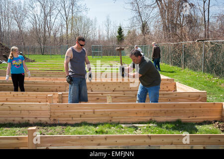 Rockford, Michigan - Volontari costruire letti in rilievo per un orto comunitario a motivo di un senior complesso di abitazioni. Foto Stock