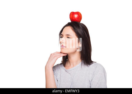 Ritratto di un simpatico brunette con un Apple sul suo capo, sfondo bianco Foto Stock