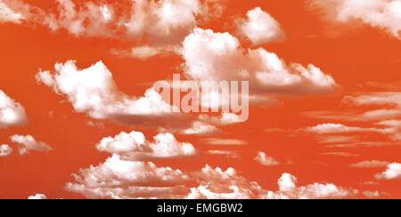 Orange Sky con fiera bianche nuvole Foto Stock