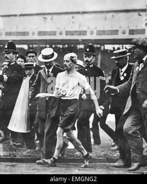 Londra 1908 Giochi Olimpici uno dei primi drammi olimpico di essere catturato sulla pellicola. Dorando Pietri è aiutato dopo si accascia appena prima di attraversare la linea di finitura nel 1908 maratona olimpica. Dorando è stato squalificato dalla gara dopo aver ricevuto aiuto da parte del funzionario che tiene il megafono nel giro finale. La foto è andato in tutto il mondo. 24 Luglio 1908 Foto Stock