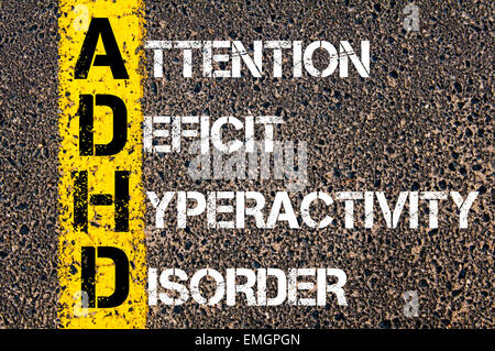 Medical acronimo ADHD come disturbo da deficit di attenzione e iperattività. Vernice gialla linea sulla strada contro lo sfondo di asfalto. Immagine concettuale Foto Stock