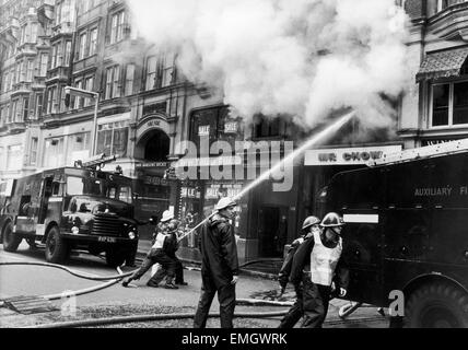 Per vigili del fuoco sciopero 1977-8. Il fumo si riversa dal primo piano del signor Chow's ristorante nel quartiere di Knightsbridge. I soldati in piedi per colpire i vigili del fuoco hanno combattuto la blaze con l aiuto di aviatori con apparecchi di respirazione. Il 2 gennaio 1978 Foto Stock