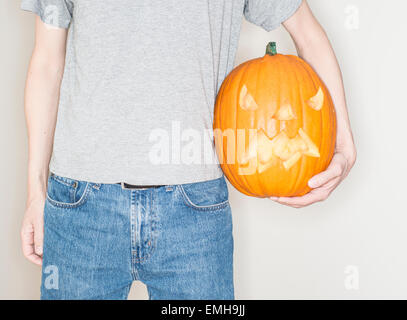 Uomo in possesso di una zucca di Halloween (jack o lantern) Foto Stock
