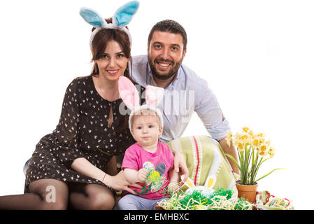 Felice Pasqua famiglia seduto con uova e fiori Foto Stock