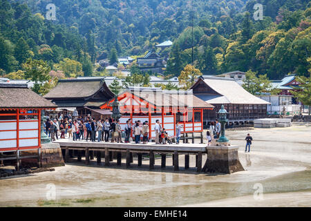 I turisti fotografare sul molo dell'isola di Miyajima, Giappone. Mare bassa marea con baring fondo sabbioso. L'isola di Miyajima island Foto Stock