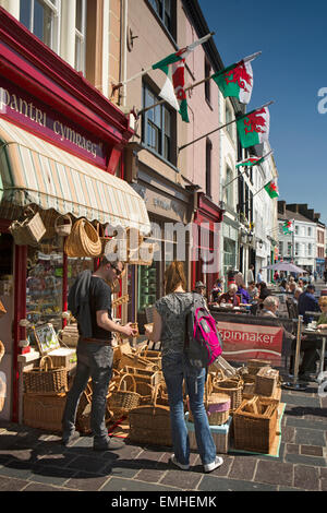 Regno Unito, Galles Gwynedd, Caernarfon, Y Maes, dipinte di colori vivaci negozi con il mercato in corso Foto Stock