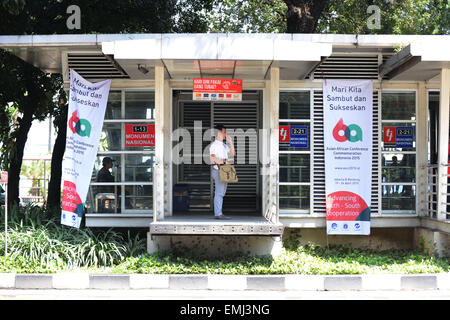 Jakarta, Indonesia. Xxi Aprile, 2015. Un uomo si trova di fronte a una stazione degli autobus appendere striscioni di commemorazione del sessantesimo anniversario della Conferenza Asian-African, noto anche come conferenza di Bandung, a Giacarta, capitale dell'Indonesia, il 21 aprile 2015. La Conferenza Asian-African commemorazione 2015 è tenuto a Jakarta e Bandung su aprile 19-24. © Liu Yun/Xinhua/Alamy Live News Foto Stock