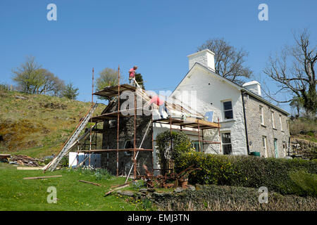 Costruttori mettere un nuovo tetto su un territorio rurale gallese casa in pietra di sole nelle zone rurali Carmarthenshire Galles Occidentale. KATHY DEWITT Foto Stock