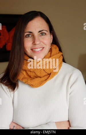 Un sorridente donna di mezza età, indossando un foulard arancione Foto Stock