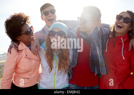 Sorridente amici in occhiali da sole di ridere su strada Foto Stock