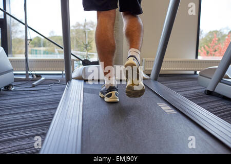 Close up uomo gambe camminando sul tapis roulant in palestra Foto Stock